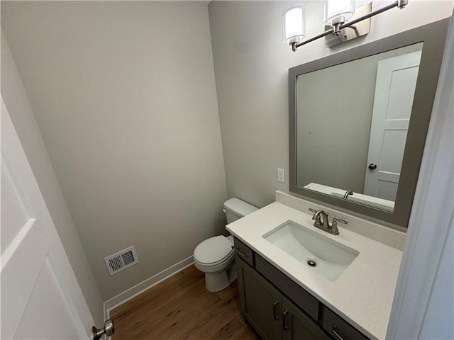 bathroom featuring toilet, hardwood / wood-style flooring, and vanity