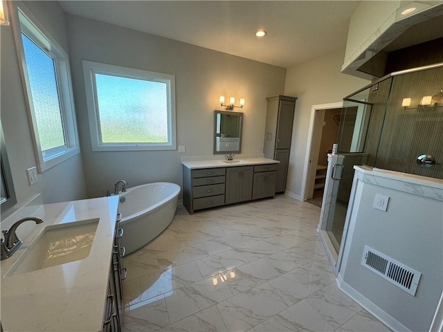 bathroom with vanity and shower with separate bathtub