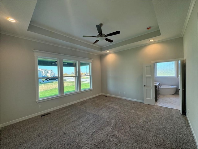 unfurnished bedroom featuring ornamental molding, carpet floors, and a raised ceiling