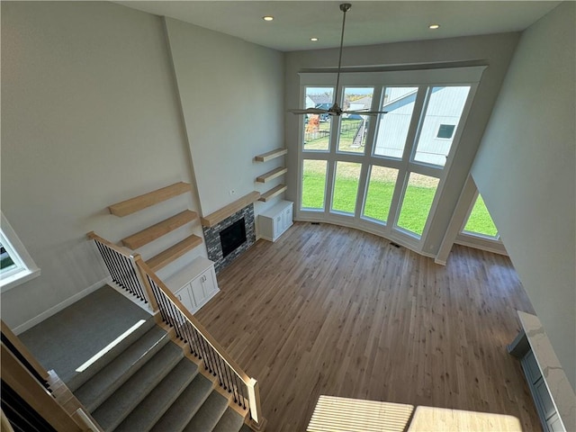 unfurnished living room with a stone fireplace, a healthy amount of sunlight, and hardwood / wood-style flooring