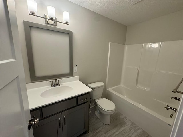 full bathroom featuring vanity, shower / tub combination, a textured ceiling, and toilet