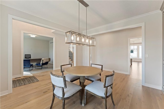 dining space with ornamental molding, light wood-type flooring, stairway, and baseboards