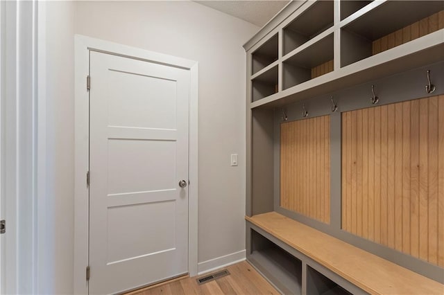 mudroom featuring light wood-type flooring, visible vents, and baseboards