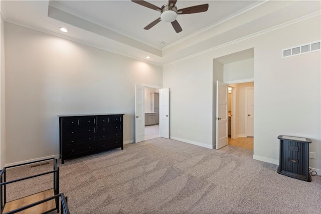 carpeted bedroom with a tray ceiling, visible vents, crown molding, and baseboards