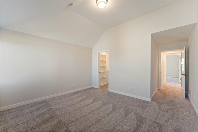 unfurnished bedroom featuring vaulted ceiling, carpet flooring, visible vents, and baseboards