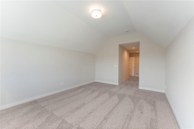 bonus room featuring light carpet, vaulted ceiling, and baseboards