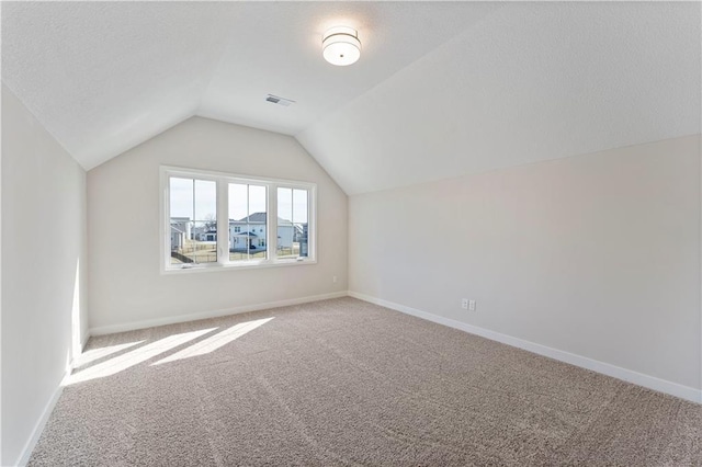 bonus room featuring vaulted ceiling, carpet flooring, visible vents, and baseboards