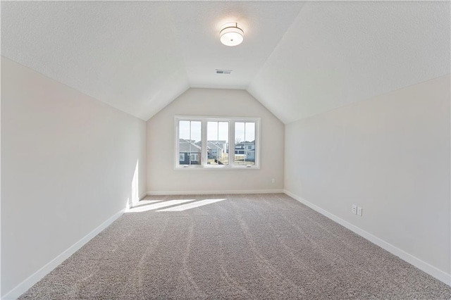 additional living space with lofted ceiling, carpet, visible vents, and baseboards