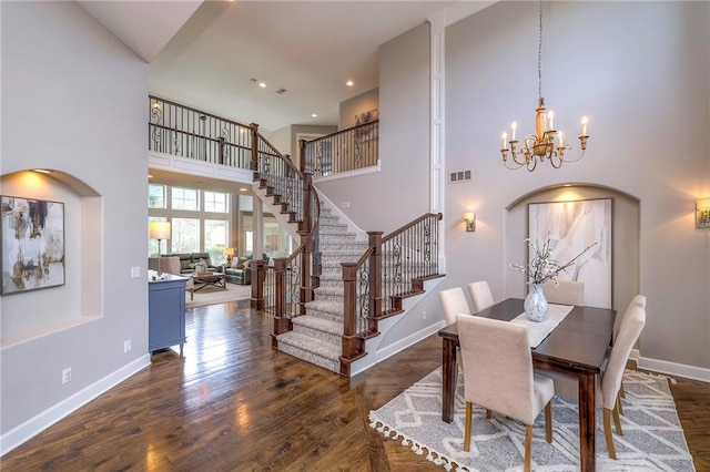 dining room featuring a notable chandelier, dark hardwood / wood-style flooring, and a high ceiling