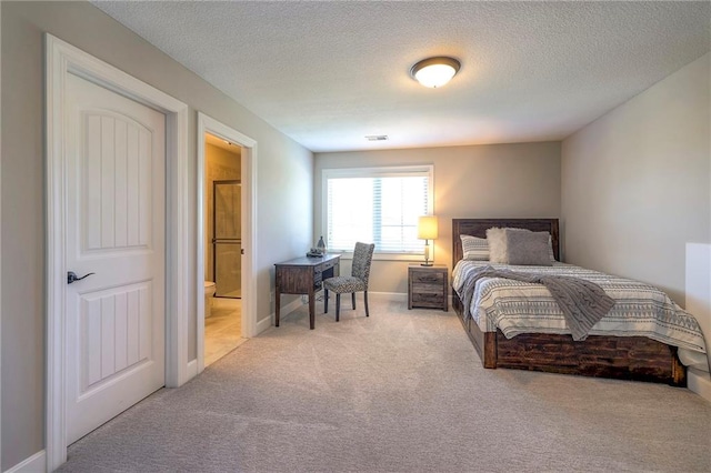 bedroom featuring connected bathroom, carpet floors, and a textured ceiling