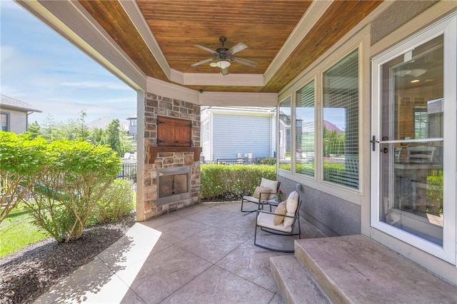 view of patio featuring an outdoor stone fireplace and ceiling fan