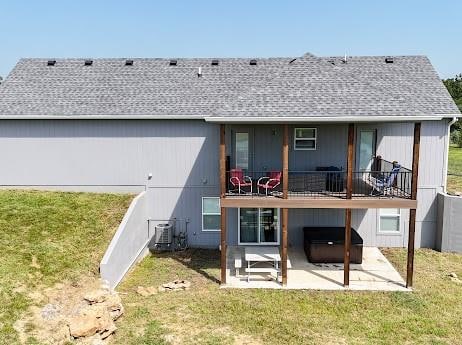 back of property featuring cooling unit, a patio, and a yard