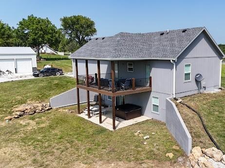 rear view of property featuring a lawn, a patio area, and a wooden deck