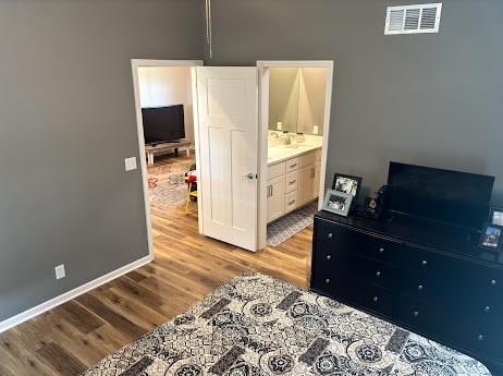 bedroom featuring light hardwood / wood-style flooring and ensuite bathroom