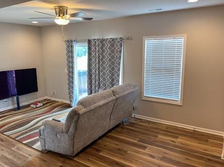 living room with ceiling fan and wood-type flooring