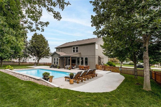 view of swimming pool with a patio, a diving board, and a yard