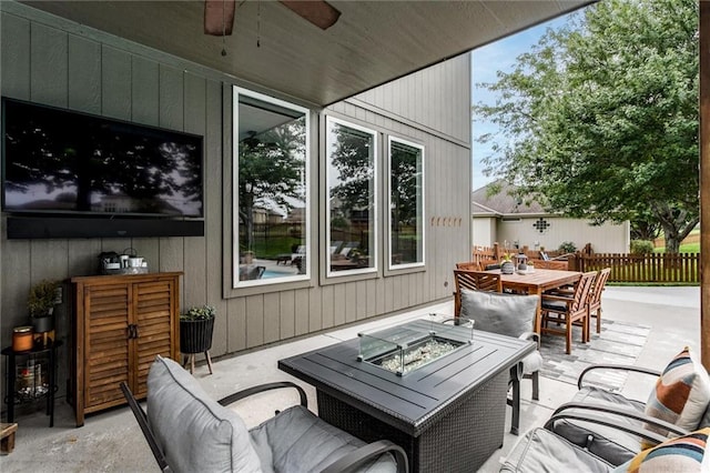 view of patio / terrace featuring ceiling fan and an outdoor living space with a fire pit