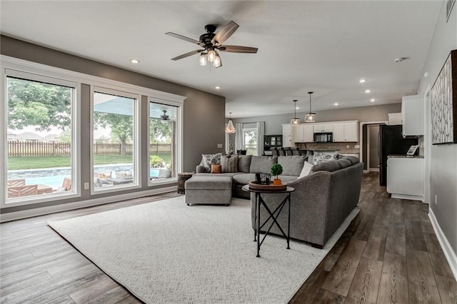 living room featuring hardwood / wood-style flooring, plenty of natural light, and ceiling fan