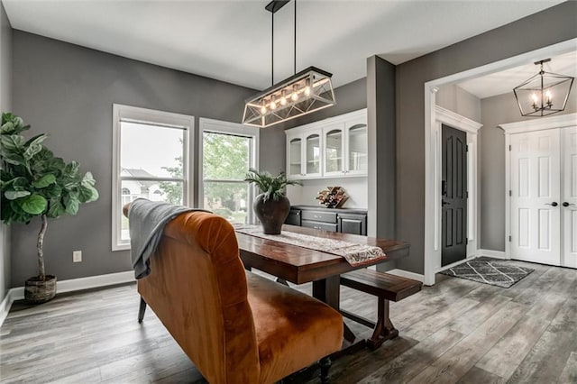 dining room with hardwood / wood-style floors and an inviting chandelier