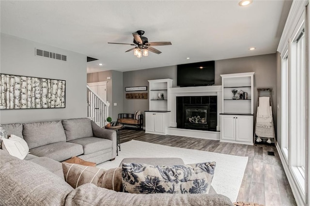 living room featuring ceiling fan, light hardwood / wood-style floors, and a fireplace