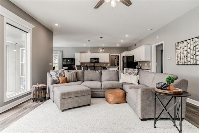 living room featuring ceiling fan, a wealth of natural light, and light hardwood / wood-style flooring