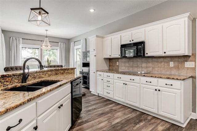 kitchen featuring sink, black appliances, pendant lighting, white cabinets, and dark wood-type flooring