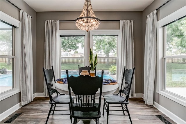 dining area featuring hardwood / wood-style flooring and a chandelier