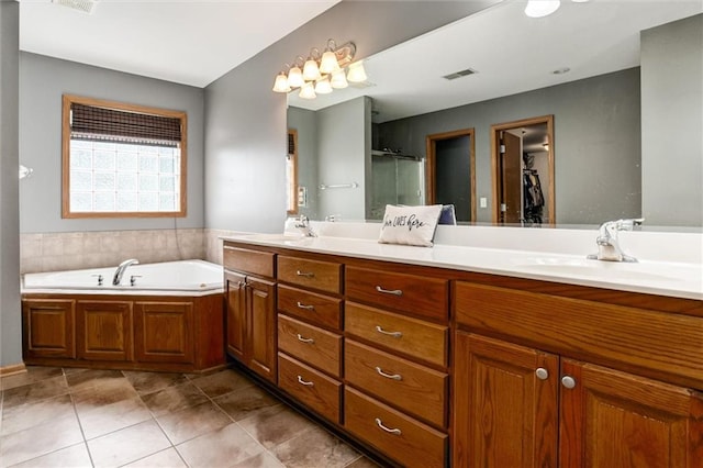 bathroom with tile patterned flooring, independent shower and bath, and vanity