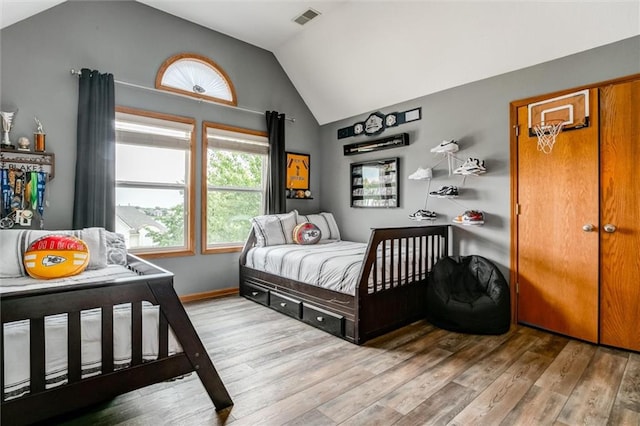 bedroom with wood-type flooring and lofted ceiling