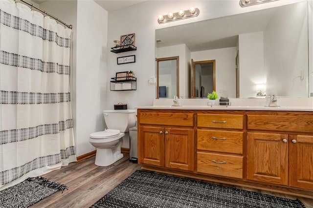 bathroom featuring hardwood / wood-style flooring, a shower with shower curtain, vanity, and toilet