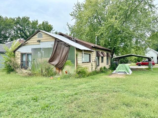 exterior space with a carport and a yard