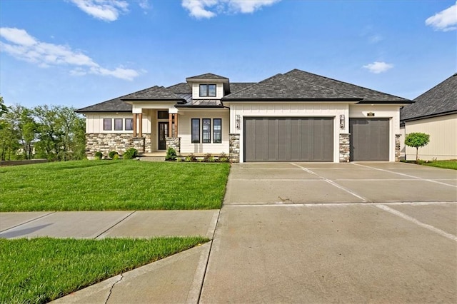 8732 N Lewis Ave, Kansas City, MO 64157 - prairie-style house featuring stone siding, an attached garage, concrete driveway, a front yard, and a standing seam roof
