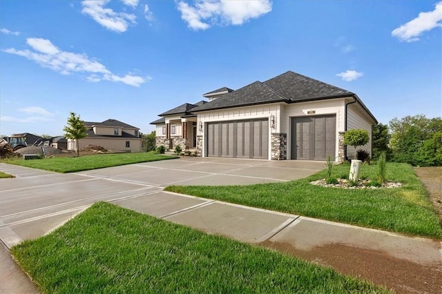 8732 N Lewis Ave, Kansas City, MO 64157 - view of front of house with a garage, stone siding, a front lawn, driveway, and roof with shingles