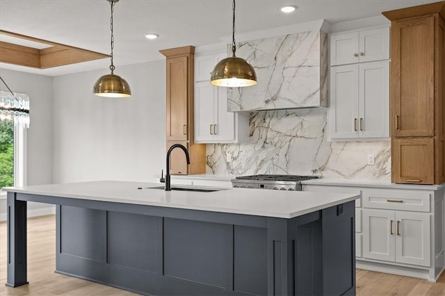8732 N Lewis Ave, Kansas City, MO 64157 - kitchen featuring light countertops, a sink, a center island with sink, tasteful backsplash, and recessed lighting