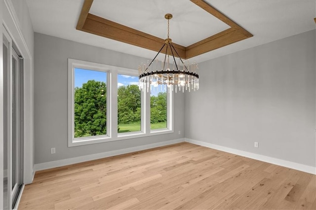 8732 N Lewis Ave, Kansas City, MO 64157 - spare room with a raised ceiling, baseboards, a chandelier, and light wood finished floors