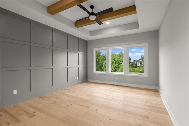 8732 N Lewis Ave, Kansas City, MO 64157 - spare room with light wood finished floors, ceiling fan, baseboards, a decorative wall, and a raised ceiling