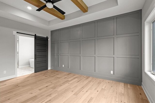 8732 N Lewis Ave, Kansas City, MO 64157 - unfurnished bedroom with a decorative wall, a barn door, light wood-type flooring, baseboards, and recessed lighting