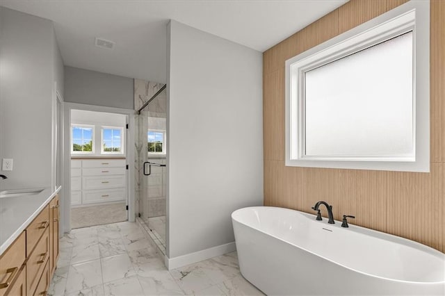 8732 N Lewis Ave, Kansas City, MO 64157 - bathroom featuring marble finish flooring, a freestanding bath, vanity, a stall shower, and wooden walls