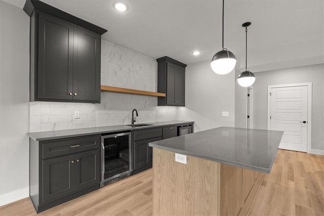 8732 N Lewis Ave, Kansas City, MO 64157 - kitchen with wine cooler, a sink, light wood-style floors, tasteful backsplash, and recessed lighting