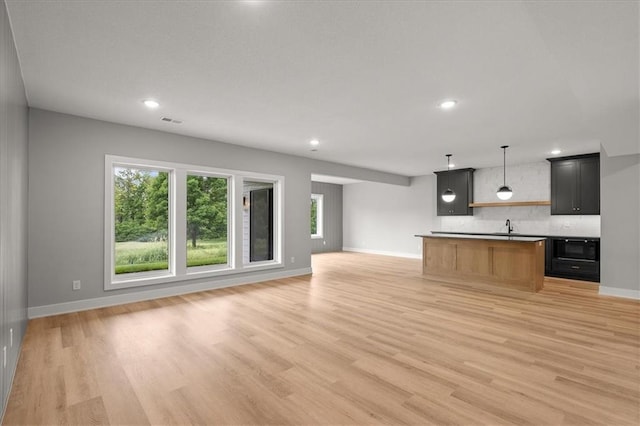 8732 N Lewis Ave, Kansas City, MO 64157 - kitchen with open floor plan, baseboards, tasteful backsplash, light wood finished floors, and recessed lighting