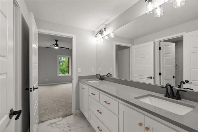 8732 N Lewis Ave, Kansas City, MO 64157 - bathroom featuring double vanity, marble look tile flooring, baseboards, and ceiling fan