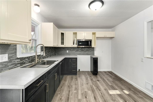 kitchen featuring sink, backsplash, and light wood-type flooring