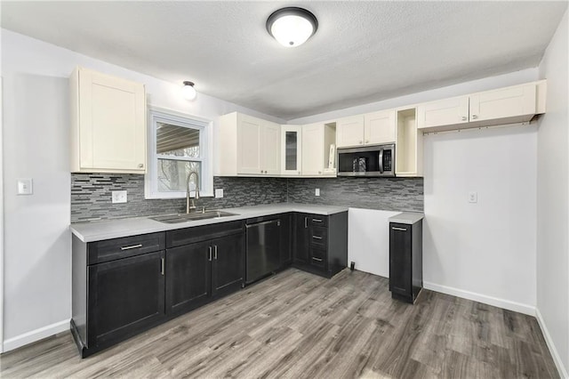 kitchen with sink, light hardwood / wood-style floors, white cabinets, and dishwasher