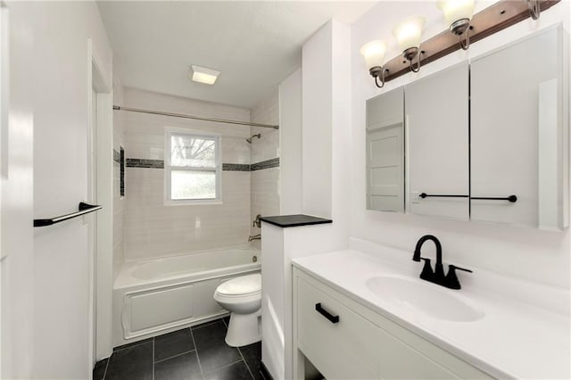 full bathroom featuring tiled shower / bath combo, vanity, tile patterned floors, and toilet