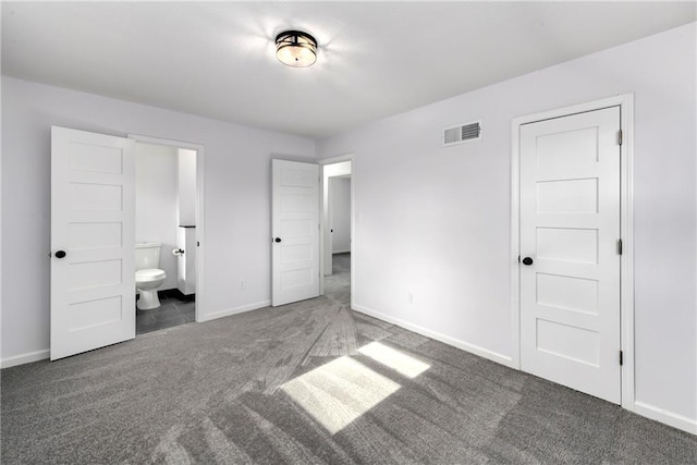 unfurnished bedroom featuring connected bathroom and dark colored carpet