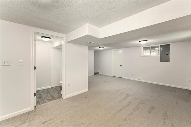 basement featuring carpet floors, electric panel, and a textured ceiling