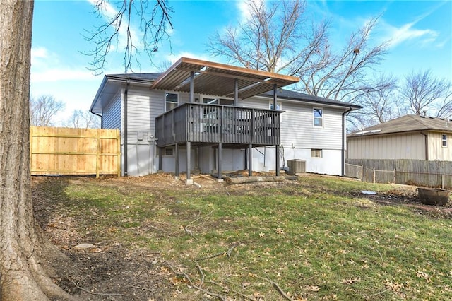 back of property featuring a deck, a lawn, and central air condition unit