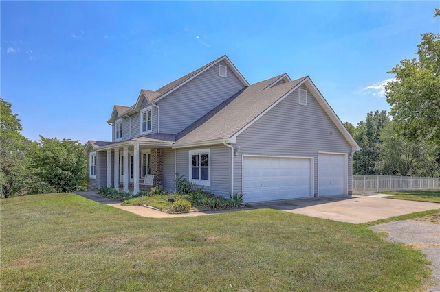 view of front of home featuring a garage, covered porch, and a front yard