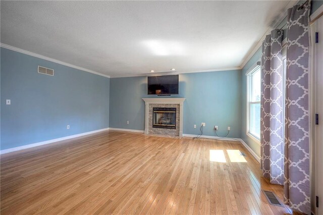 unfurnished living room featuring crown molding and light wood-type flooring