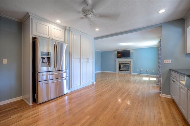 kitchen with stainless steel fridge, white cabinetry, a textured ceiling, ceiling fan, and light hardwood / wood-style floors